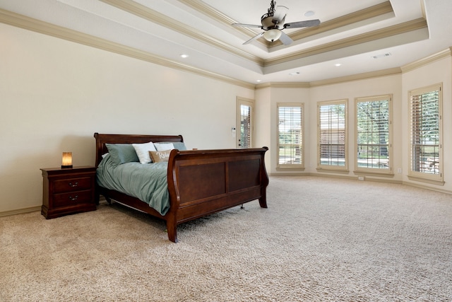 carpeted bedroom with multiple windows, a raised ceiling, ceiling fan, and ornamental molding