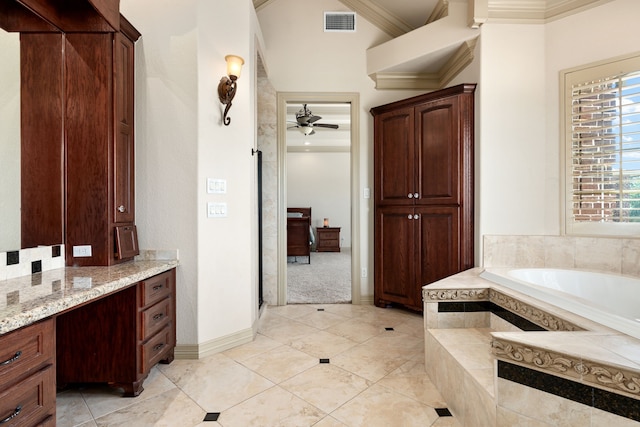 bathroom featuring ceiling fan, crown molding, vanity, and a relaxing tiled tub