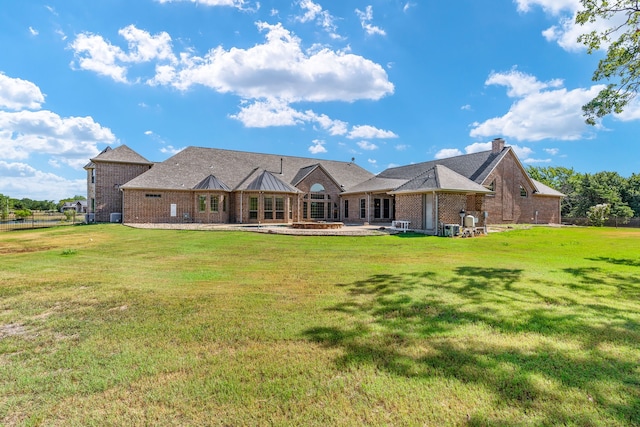 back of property featuring a lawn and a patio