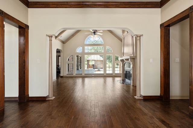 unfurnished living room featuring dark hardwood / wood-style flooring, decorative columns, vaulted ceiling, ceiling fan, and crown molding