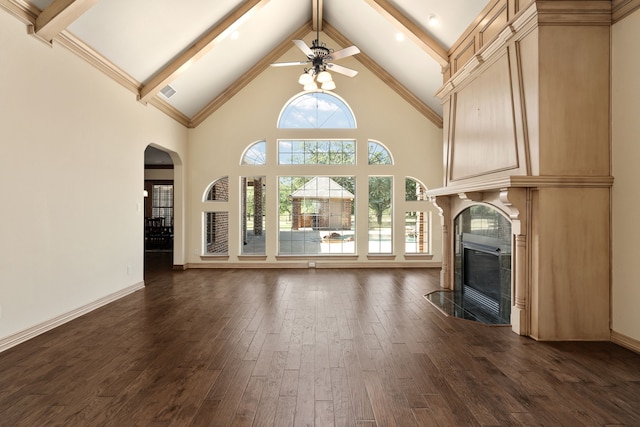 unfurnished living room featuring a fireplace, dark hardwood / wood-style flooring, high vaulted ceiling, and plenty of natural light