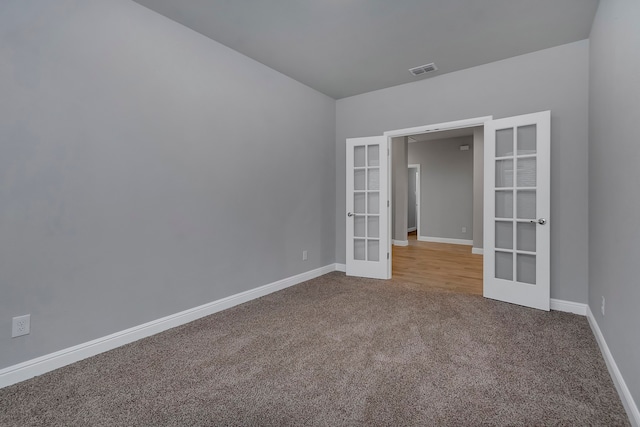 unfurnished room featuring french doors and carpet floors