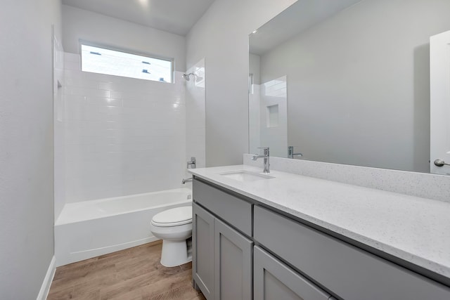 full bathroom featuring tiled shower / bath combo, vanity, wood-type flooring, and toilet