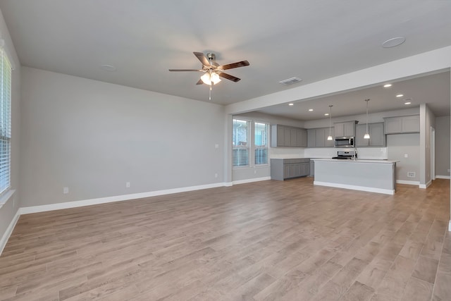 unfurnished living room with light wood-type flooring and ceiling fan