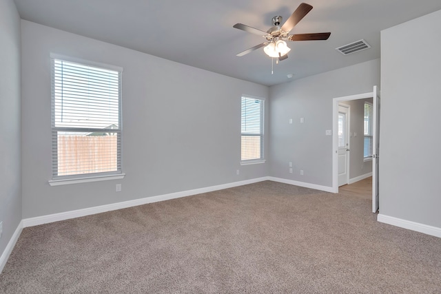 unfurnished room with carpet floors, a wealth of natural light, and ceiling fan