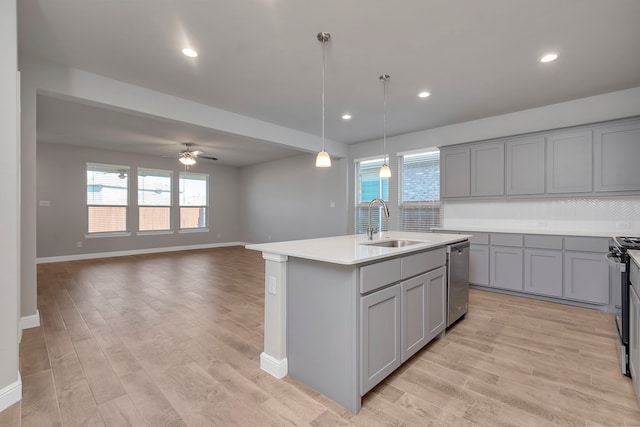 kitchen featuring sink, plenty of natural light, ceiling fan, and a center island with sink