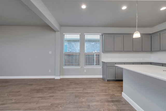 kitchen with hanging light fixtures, light hardwood / wood-style flooring, and gray cabinets