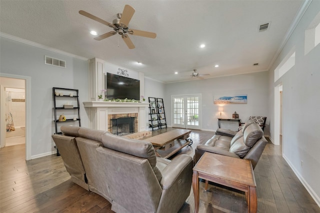 living room featuring french doors, ceiling fan, wood-type flooring, and a brick fireplace