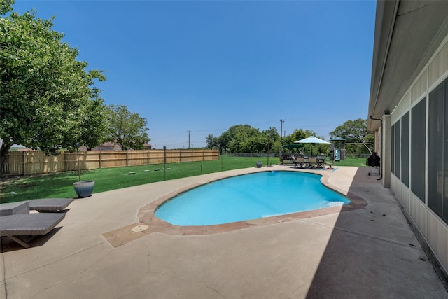 view of pool with a patio and a lawn