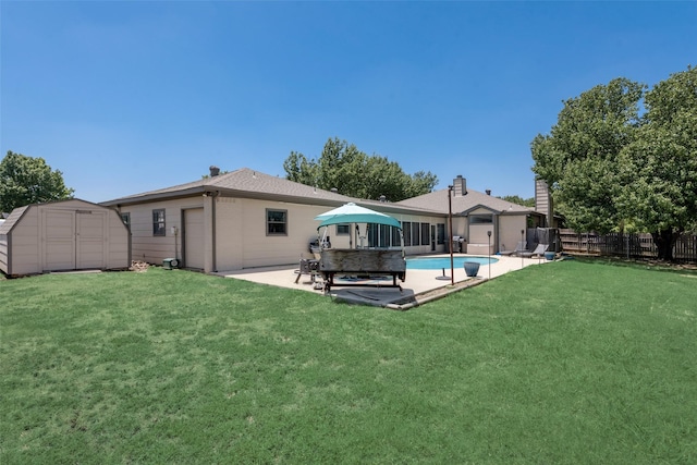 back of house featuring a fenced in pool, a yard, a storage shed, and a patio