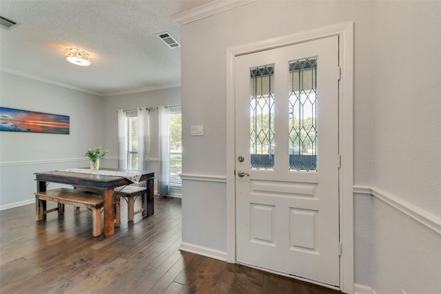 foyer entrance with crown molding, dark wood-type flooring, and a textured ceiling