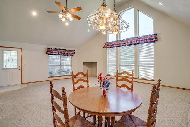 dining room featuring light carpet, ceiling fan with notable chandelier, and high vaulted ceiling