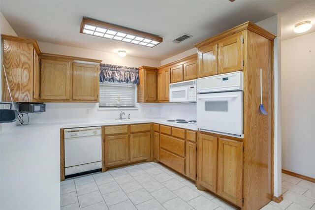 kitchen featuring white appliances, sink, and light tile patterned floors