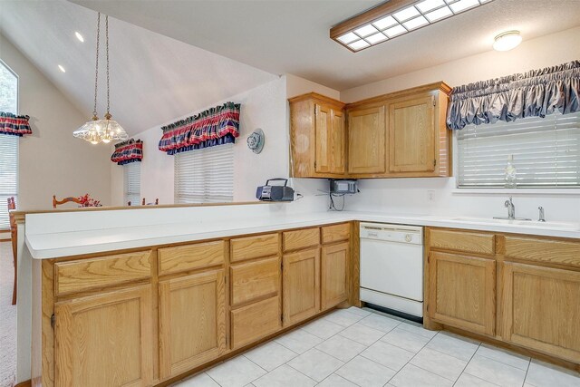 kitchen featuring pendant lighting, sink, lofted ceiling, white dishwasher, and kitchen peninsula