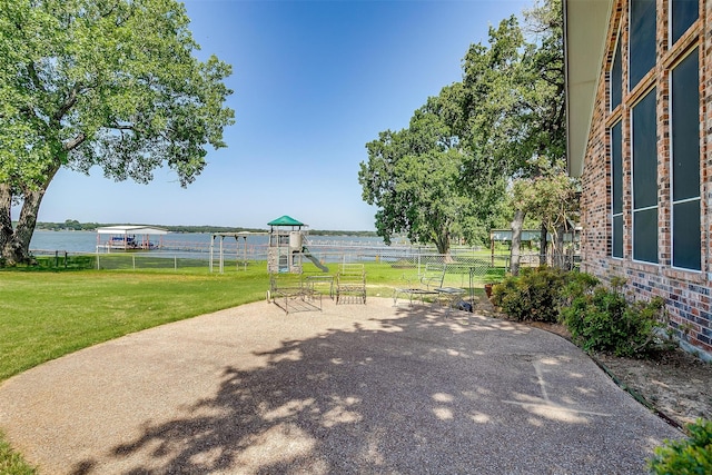 view of patio / terrace with a playground and a water view