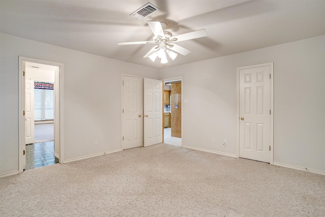 carpeted spare room with ceiling fan