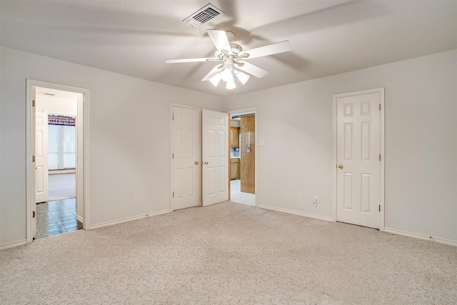 carpeted empty room featuring ceiling fan