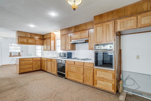 kitchen with black appliances, sink, kitchen peninsula, light carpet, and a textured ceiling