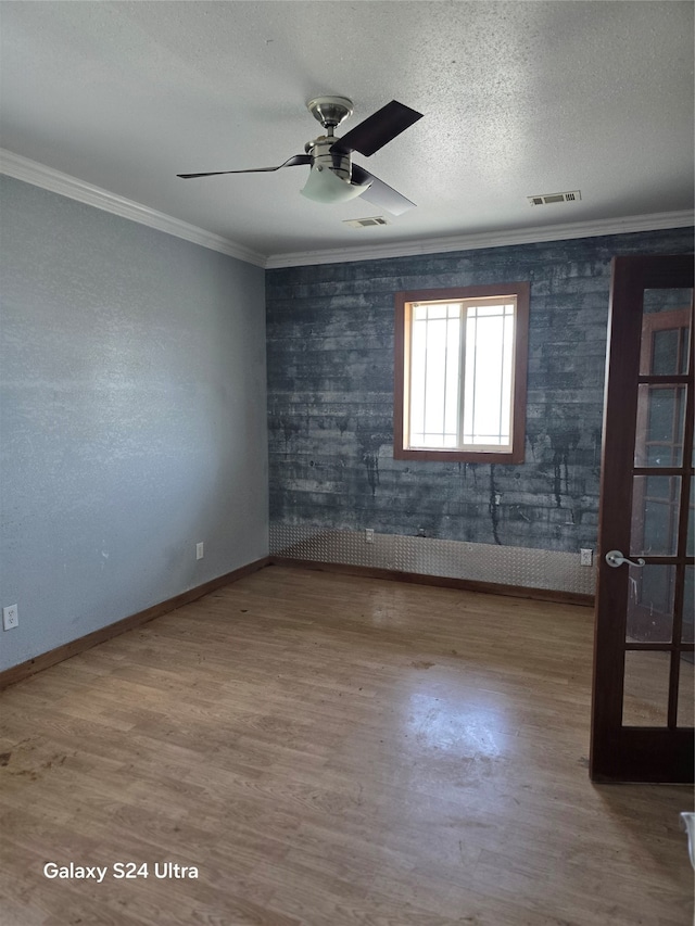 unfurnished room with a textured ceiling, ceiling fan, hardwood / wood-style floors, and crown molding