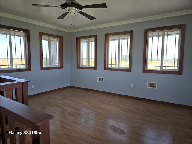 spare room featuring dark hardwood / wood-style flooring, ceiling fan, and crown molding