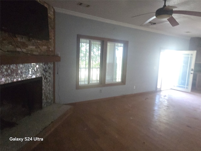 unfurnished living room featuring crown molding, a fireplace, ceiling fan, and hardwood / wood-style flooring