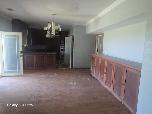 interior space featuring a chandelier, pendant lighting, crown molding, and stainless steel microwave