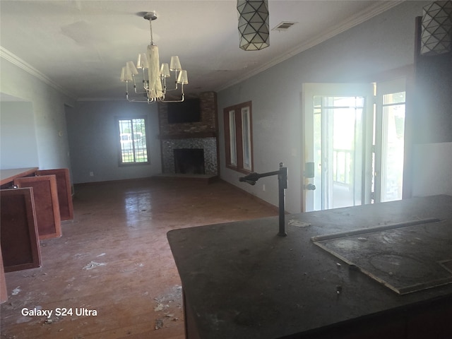 unfurnished living room featuring a large fireplace, crown molding, and an inviting chandelier