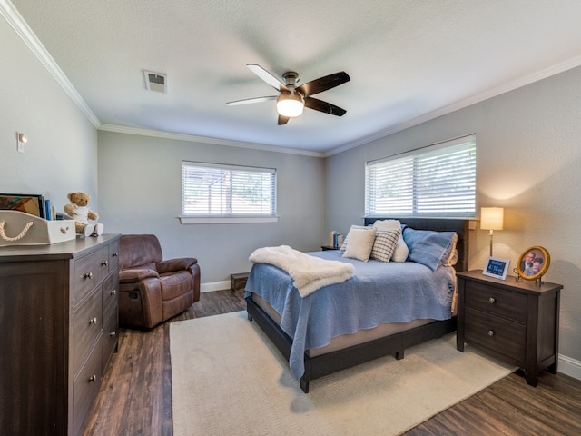 bedroom with crown molding, dark hardwood / wood-style flooring, and ceiling fan