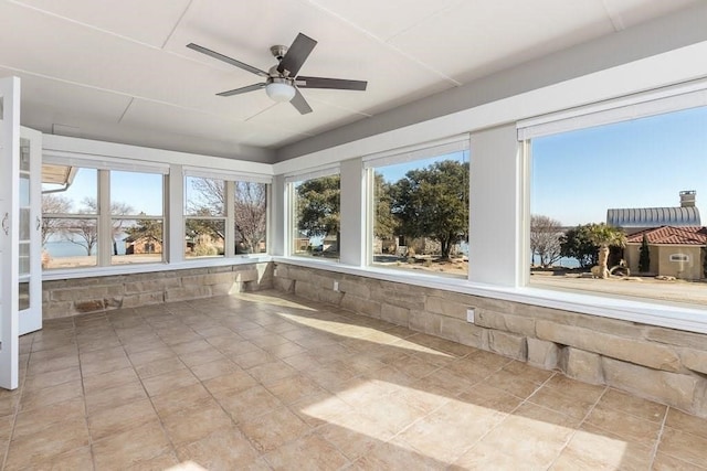 unfurnished sunroom featuring ceiling fan