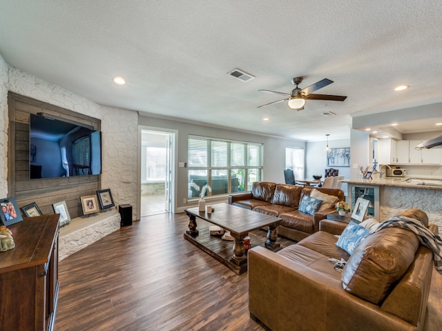 living room featuring a textured ceiling, dark hardwood / wood-style flooring, and ceiling fan