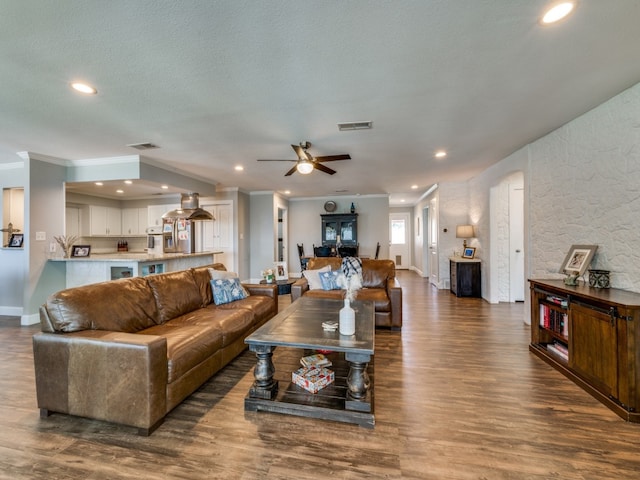 living room featuring ceiling fan, crown molding, a textured ceiling, and dark hardwood / wood-style flooring