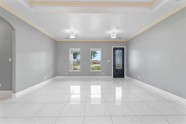 foyer entrance featuring a raised ceiling and ornamental molding