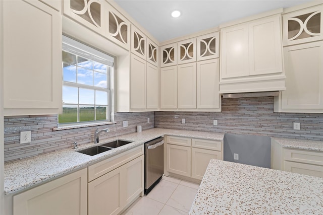 kitchen featuring dishwasher, light stone countertops, sink, and tasteful backsplash