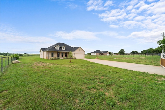 view of front of house with a garage, a rural view, and a front yard