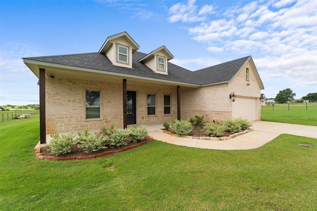 view of front of home with covered porch, a garage, and a front yard