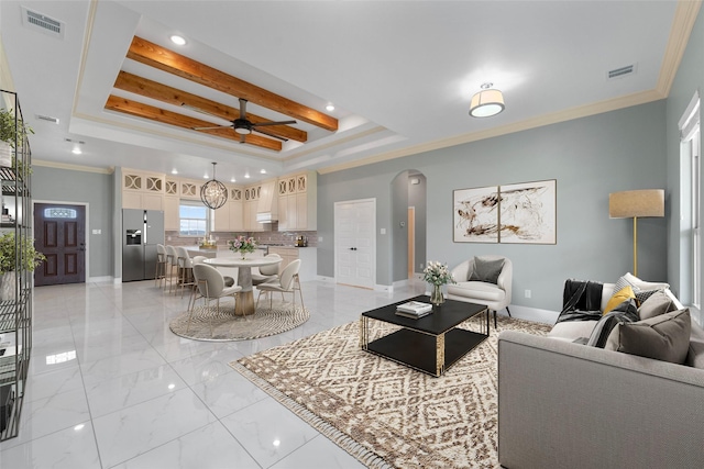 living room featuring a raised ceiling, ceiling fan, and ornamental molding