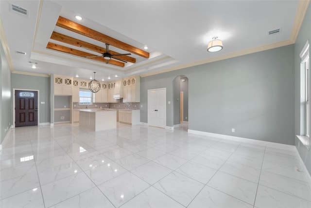 interior space with beamed ceiling, a raised ceiling, ceiling fan, and ornamental molding