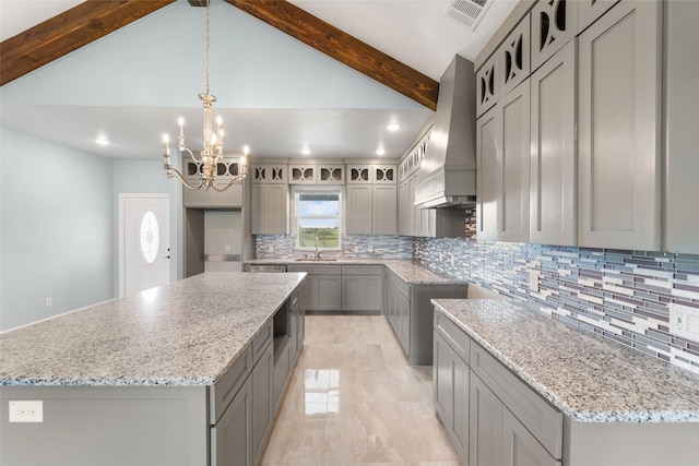 kitchen featuring a large island, sink, hanging light fixtures, gray cabinets, and custom exhaust hood