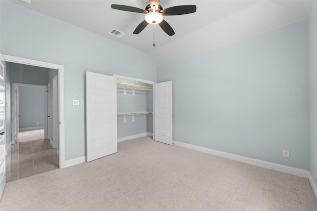 unfurnished bedroom featuring ceiling fan, light colored carpet, lofted ceiling, and a closet