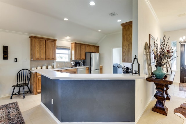 kitchen with sink, kitchen peninsula, lofted ceiling, light tile patterned flooring, and appliances with stainless steel finishes