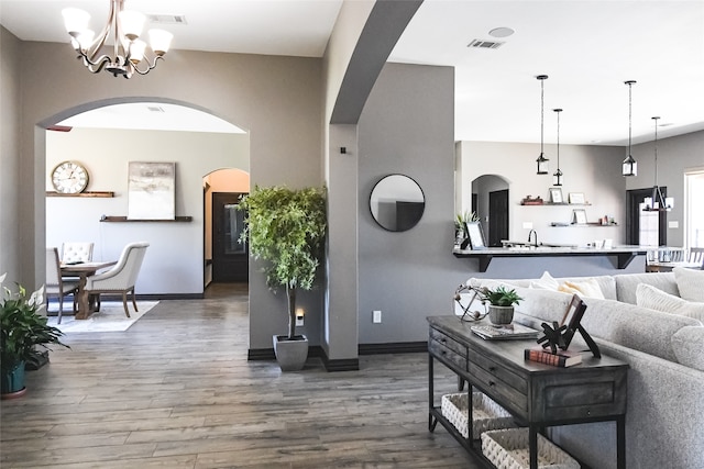 living room featuring dark hardwood / wood-style flooring, sink, and an inviting chandelier