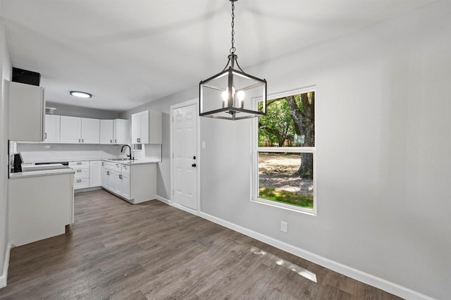 kitchen with white cabinets, sink, hanging light fixtures, dark hardwood / wood-style floors, and range