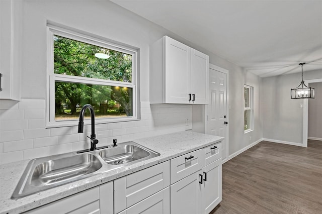 kitchen with white cabinetry, sink, dark hardwood / wood-style floors, decorative light fixtures, and decorative backsplash