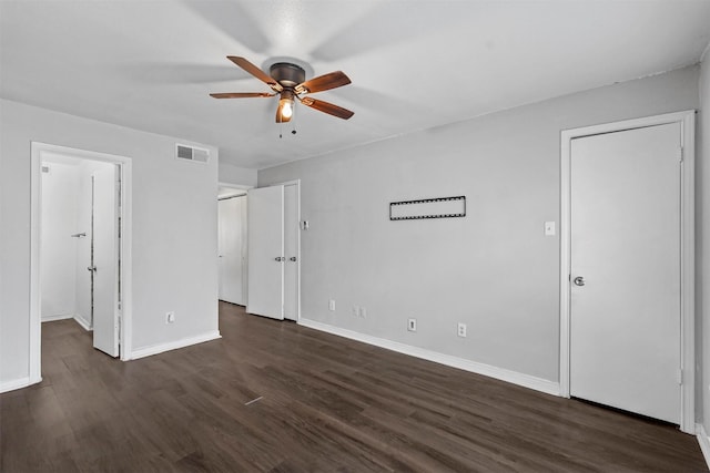 unfurnished bedroom featuring baseboards, visible vents, dark wood-style flooring, and ceiling fan