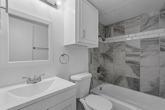 full bathroom featuring tiled shower / bath combo, toilet, and vanity