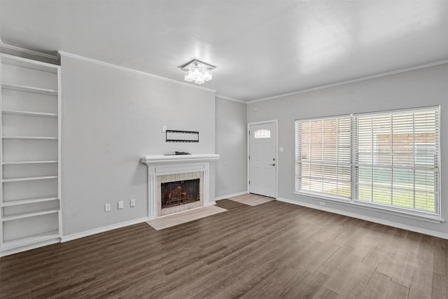 unfurnished living room with a fireplace, wood-type flooring, a chandelier, and crown molding