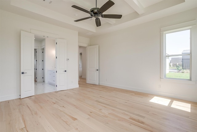 unfurnished bedroom featuring a raised ceiling, ceiling fan, and light hardwood / wood-style floors