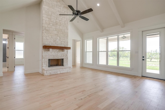 unfurnished living room with high vaulted ceiling, ceiling fan, a fireplace, and light wood-type flooring