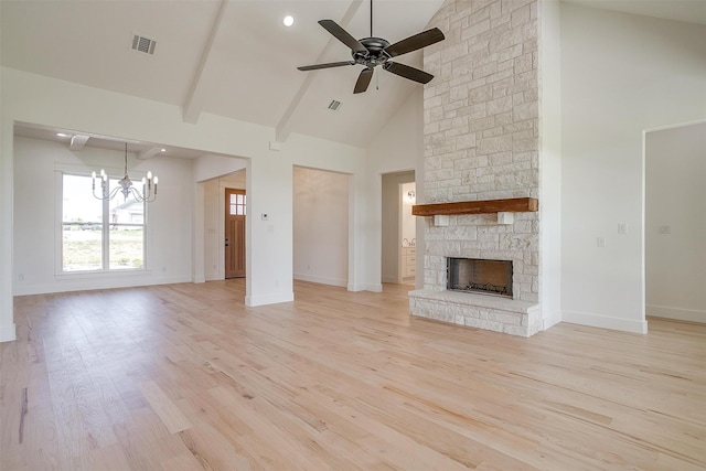 unfurnished living room with ceiling fan with notable chandelier, a fireplace, high vaulted ceiling, and light hardwood / wood-style floors