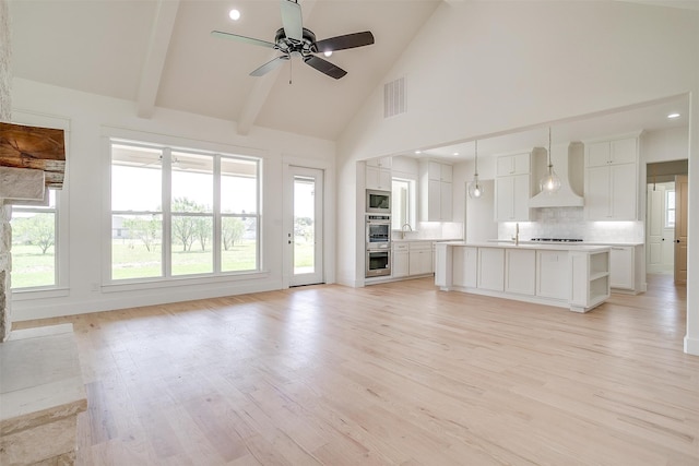 unfurnished living room featuring beamed ceiling, high vaulted ceiling, ceiling fan, and light hardwood / wood-style floors